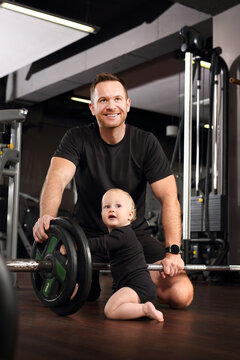 Training with a child. Dad and baby at the gym