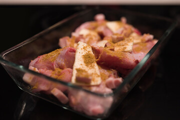 Fresh rabbit thighs and parts prepared for slow time baking in oven