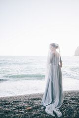 Beautiful woman bride under a veil near the sea. wedding, happiness, lifestyle