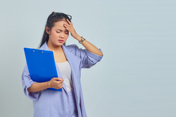 Obraz premium Portrait of depressed young Asian business woman holding document folder, feeling dizzy and severe headache isolated on purple background
