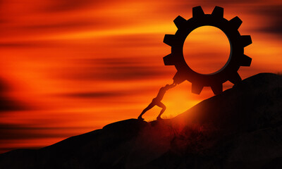 Young man Pushing Gear Uphill At sunset. Businessman Push The Heavy Cogwheel up the top of mountain. Sisyphus , Hard Work and Business Concept 