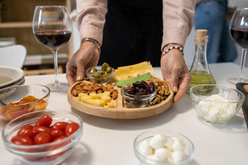 Close-up of woman serving appetizers on the plate on dining table during party