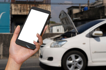 Close up hand of woman using smartphone and blur of her broken car parking on the road.