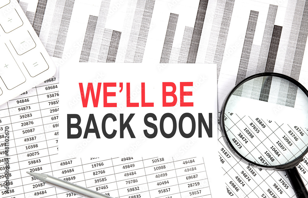 Aufkleber we'll be back soon text on paper with calculator,magnifier ,pen on the graph background