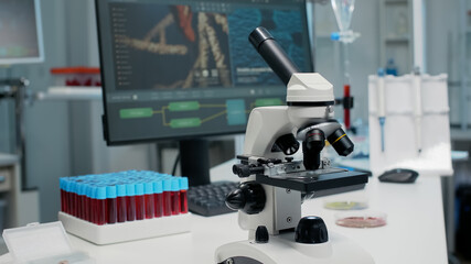 Close up of laboratory microscope on desk with medical research instruments. Empty room with...