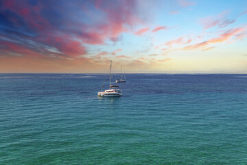 Fototapeta premium Yacht drifting on sea surface under blue cloudless sky