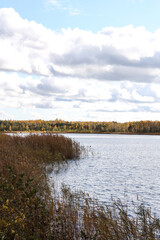 Cloudy Overcast autumn view with small river and cloudy sky.