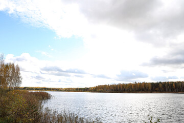 Cloudy Overcast autumn view with small river and cloudy sky.