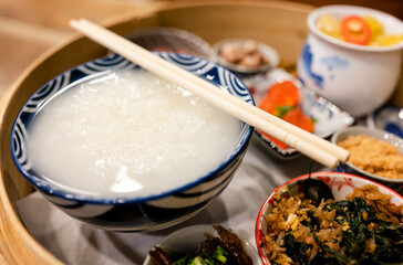 Chinese Porridge served with various side dishes on a steamed bowl