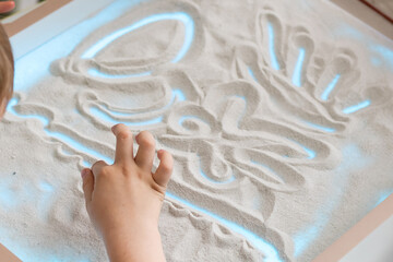 Children paint in the interactive sand table , sand animation