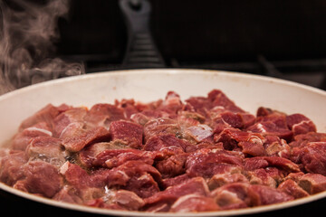 Sliced beef meat fried in a pan close-up.