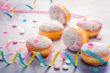 Traditional Berliner for carnival and party. German Krapfen or donuts with streamers and confetti.