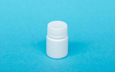 White different medical or cosmetic jars on a blue background as a concept of cosmetology of medecine and treatment