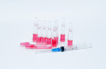 Medicinal or cosmetic ampoules jars of vaccines isolated on white background as a concept of cosmetology medicine and treatment with syringes injections.