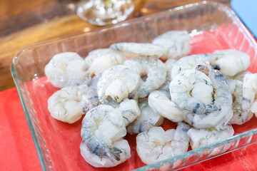 A bowl of fresh raw pacific white shrimp peeled with tail on.