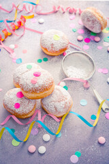 Traditional Berliner for carnival and party. German Krapfen or donuts with streamers and confetti.