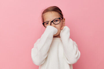 Portrait of happy smiling child girl in a white sweater and glasses isolated background