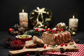 Traditional French terrine covered with bacon on dark wooden background with Christmas decorations