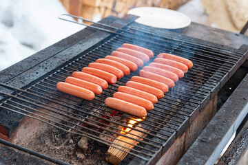 delicious sausages are grilled on a barbecue outside in winter