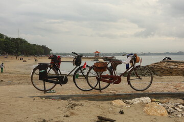 Fototapeta na wymiar a pair of vintage old bicycles parked on the beach of sanur bali 