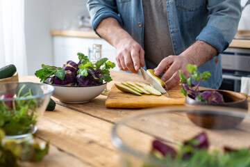 Cooking healthy and tasty breakfast or lunch. Male hands preparing vegetarian food at home kitchen