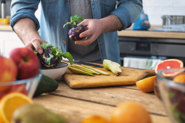 Cooking healthy and tasty breakfast or lunch. Male hands preparing vegetarian food at home kitchen