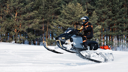 In deep powder snowdrift snowmobile rider driving fast.