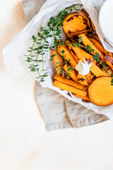 Healthy homemade baked sweet potato wedges with cream dip sauce and herbs. Healthy snack.
