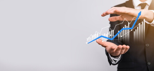 Businessman holding graph growth and increase of chart positive indicators in his...