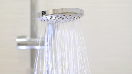 turning on and off shower head in bathroom, water flow in front of camera, falling drops. Close-up