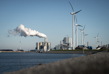 Fossil fuel (coal) power station and wind turbines in the Eemshaven generating power. Energy...