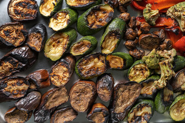 Grilled zucchini, mushrooms and Brussels sprouts. Laid out on a stainless steel baking sheet, top view.