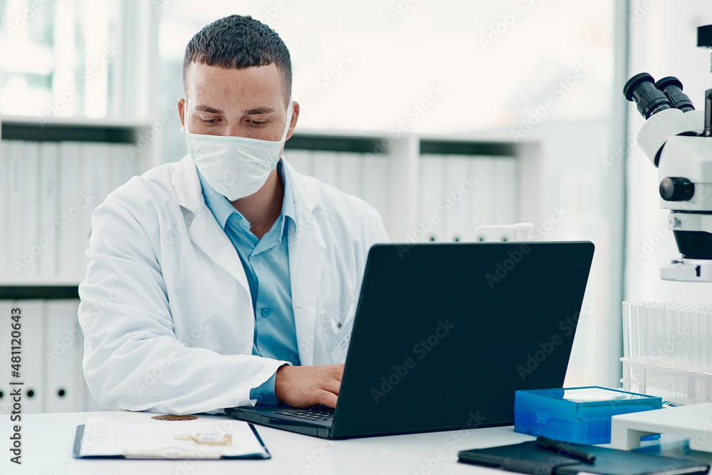 Poster not your average drug trial. shot of a young scientist using a laptop while working on a coronavirus