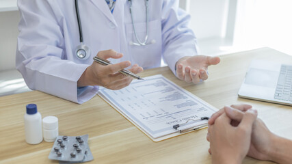 Male doctor made a diagnosis on a male patient and gave advice on treatment methods in the hospital examination room, Helping patients with medical advice, Health care counseling.