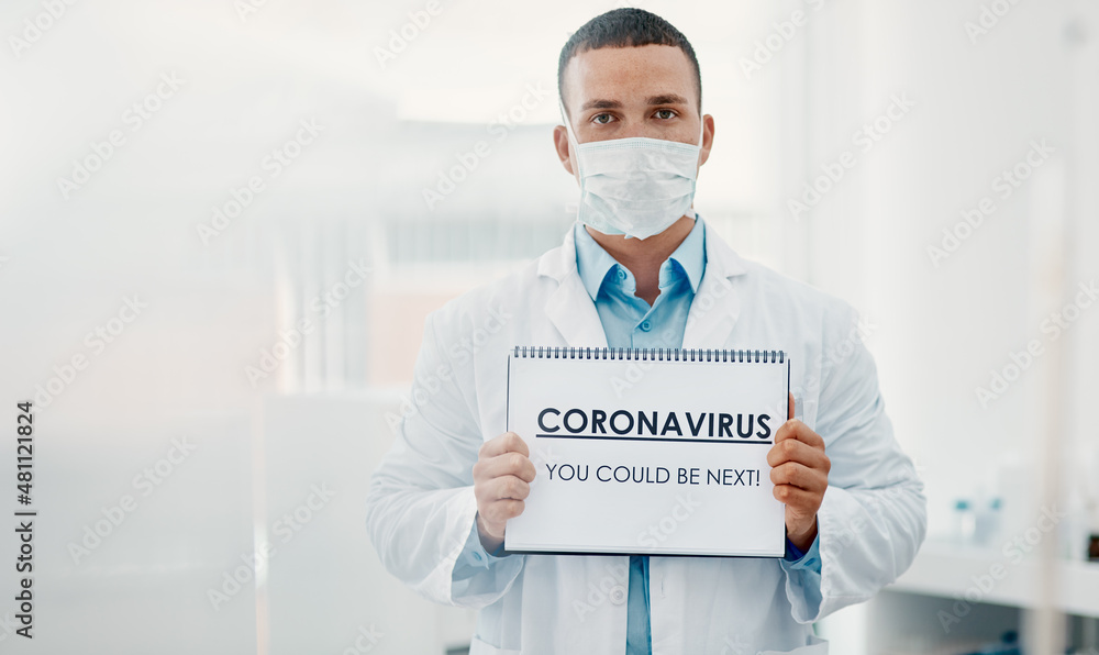 Poster were all at risk. shot of a scientist holding a sign with coronavirus-you could be next on it in a l