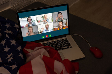american or usa national flag. working from home on computer notebook laptop on webcam video call...