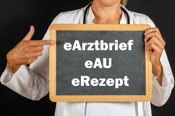 Ärztin zeigt auf eine Tafel auf der eArztbrief, eAU und eRezept für die neue...