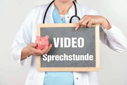Ärztin mit einem Sparschwein und einer Tafel auf der Video Sprechstunde steht