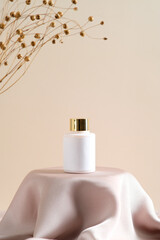 Cosmetic lotion bottle mockup on dais podium with dry flowers on beige background. Natural beauty...