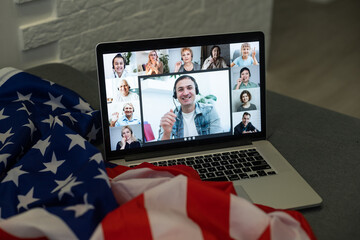 american or usa national flag. working from home on computer notebook laptop on webcam video call conference in quarantine.