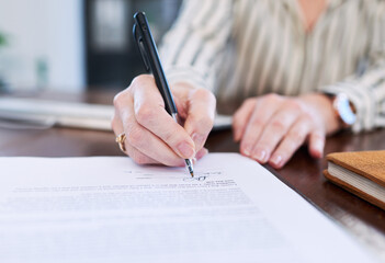 Signing off a new deal. Closeup shot of an unrecognisable businesswoman signing paperwork in an office.