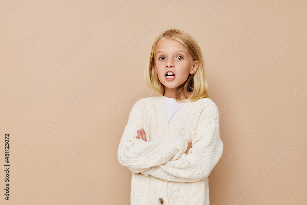 Wall mural portrait of a smiling little cutie in a sweater, grimaces kids lifestyle concept