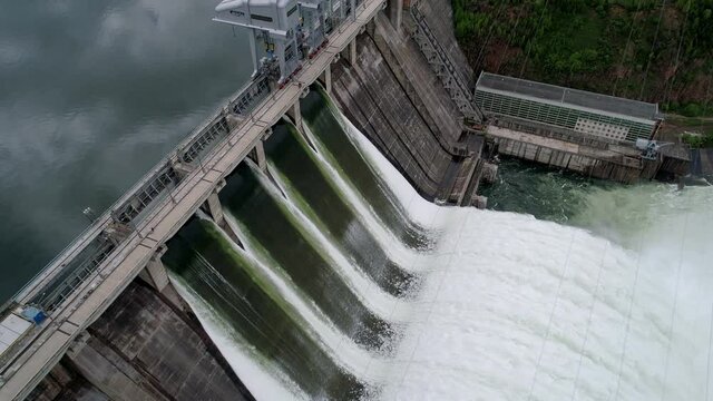 Aerial side view of water discharge at hydroelectric power plant