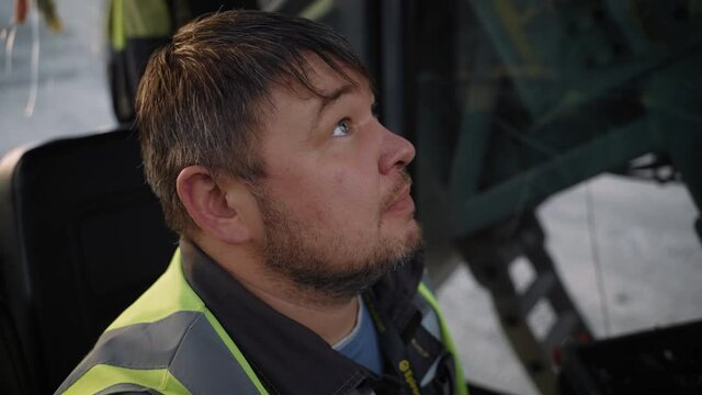 The operator in the cabin of the drilling machine at the moment of lifting the boom.