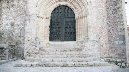 Fototapeta na wymiar Puerta con arco decorado de iglesia antigua europea