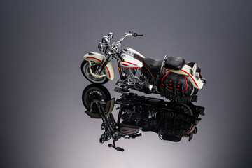 Fototapeta na wymiar Toy motorcycle on a piece of black acrylic 