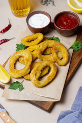 Fried squid rings with two sauces, lemon and herbs. Fast food. Appetizer.
