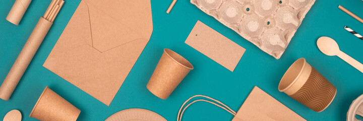 Banner. Flat lay with eco-friendly tableware and sustainable packaging. Kraft paper food packaging on green background. Street food paper packaging, recyclable paperware, zero waste packaging concept