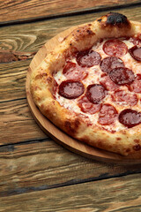 Pepperoni pizza on rustic, vintage style wood background. Top view