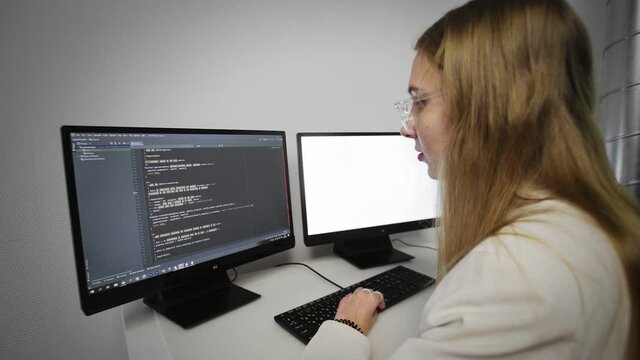 Programmer girl scrolling HTML web page code. Programming